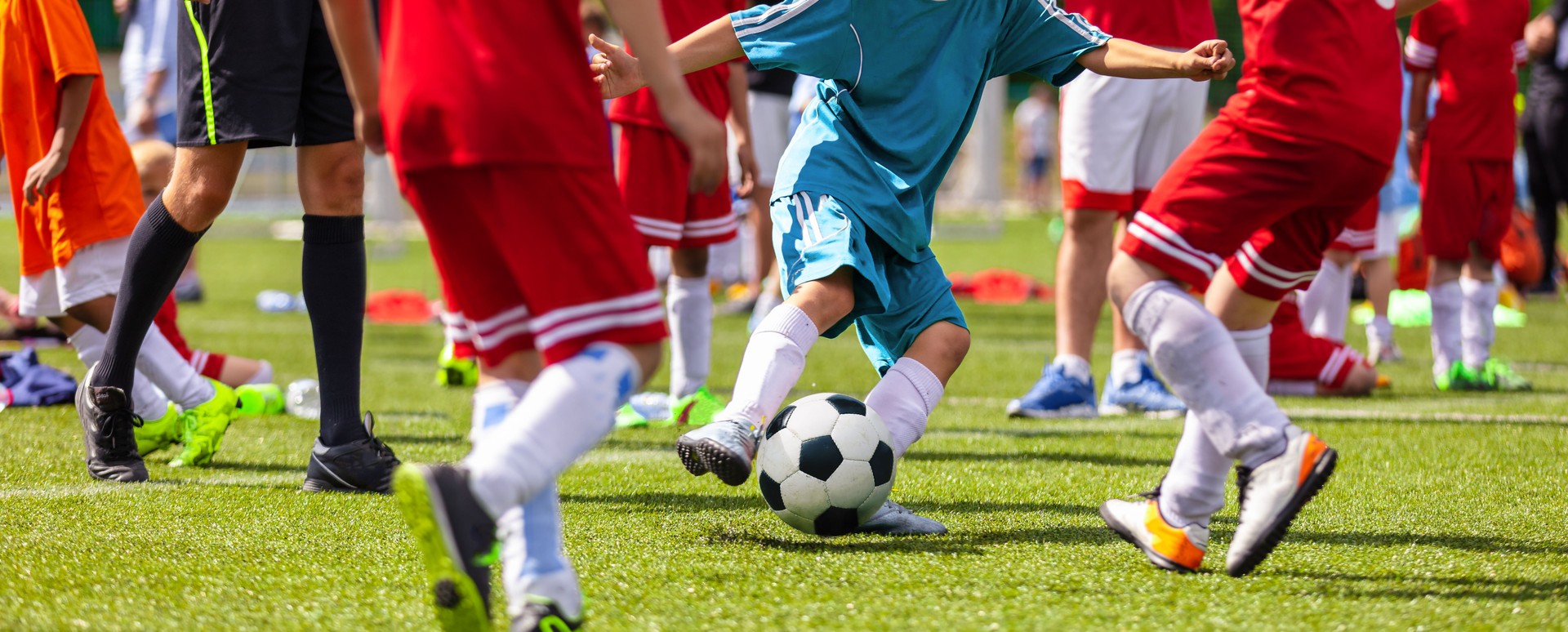 Jugendfußballwettbewerb.  Jungen, die ein Fußballspiel spielen. Fußballspiel zwischen jungen Schulmannschaften. Juniorenwettbewerb zwischen Spielern, die einen Fußball laufen und treten. Spiel des Fußballturniers